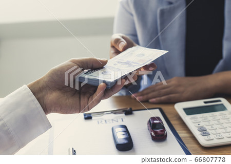The car salesman handed the keys to the customer who passed the car purchase loan conditions ,Car rental agreement Concept. 66807778