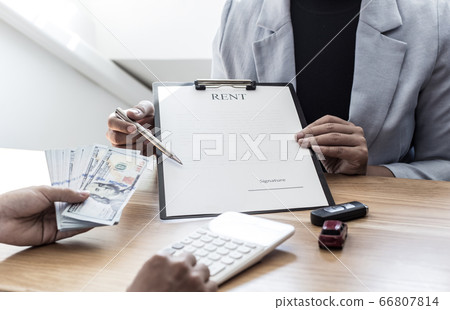 The car salesman handed the keys to the customer who passed the car purchase loan conditions ,Car rental agreement Concept. 66807814