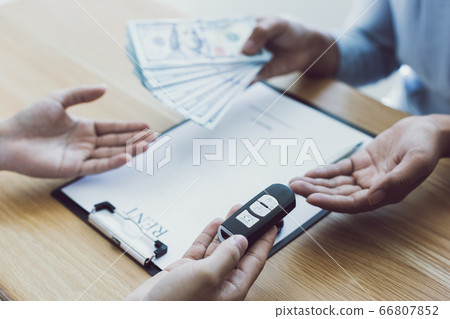 The car salesman handed the keys to the customer who passed the car purchase loan conditions ,Car rental agreement Concept. 66807852