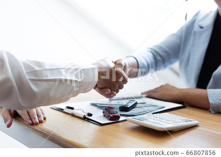 The car salesman handed the keys to the customer who passed the car purchase loan conditions ,Car rental agreement Concept. 66807856