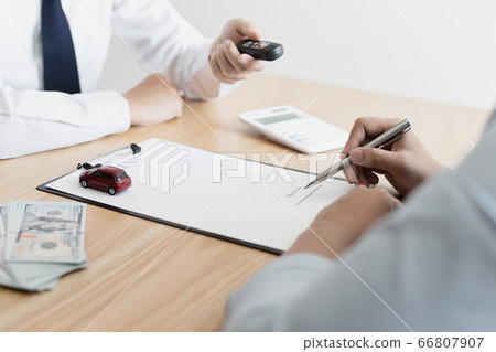 The car salesman handed the keys to the customer who passed the car purchase loan conditions ,Car rental agreement Concept. The car salesman handed the keys to the customer who passed the car purchase loan conditions ,Car rental agreement Concept. 66807907