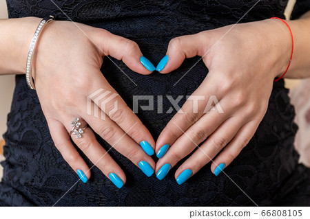 Russia, Saint Petersburg. The pregnant woman gently folded her hands like a heart on her tummy. Russia, Saint Petersburg. The pregnant woman gently folded her hands like a heart on her tummy. 66808105