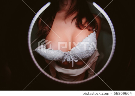 black bra being remove by a man hand. 66809664