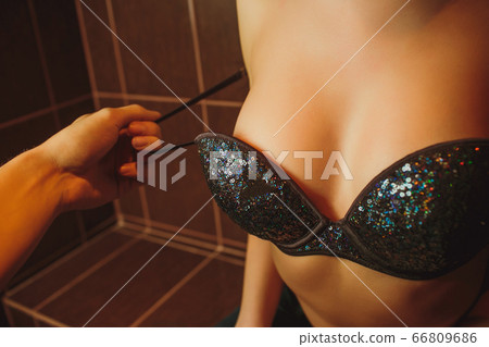 black bra being remove by a man hand. black bra being remove by a man hand. 66809686