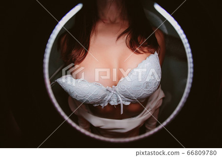 black bra being remove by a man hand. 66809780