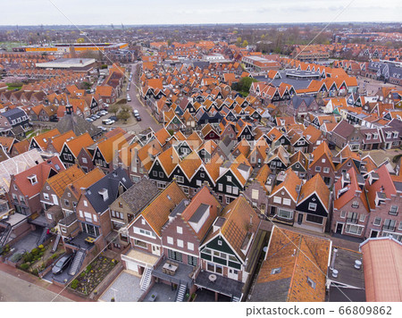 Aerial Shot of the typical Dutch houses in Volendam showing the typical lines of homes and street with harbor. Volendam town is popular touristical place in Netherlands 66809862