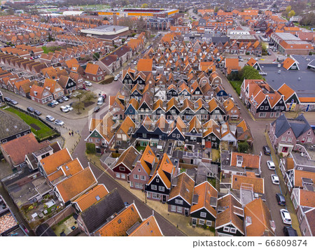 Aerial Shot of the typical Dutch houses in Volendam showing the typical lines of homes and street with harbor. Volendam town is popular touristical place in Netherlands 66809874