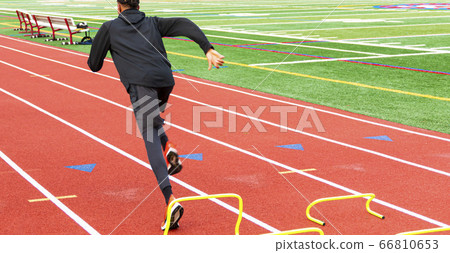 African american runner sprining over yhellow mini 66810653