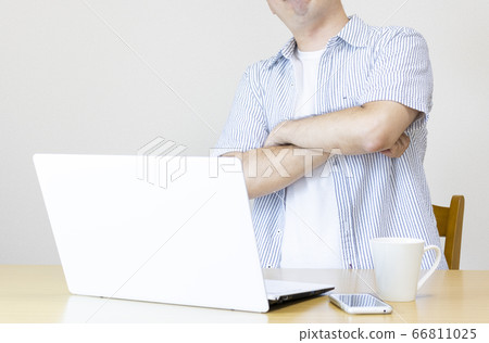 A man at home working on a laptop in plain clothes and thinking. Image of working from home and side business 66811025