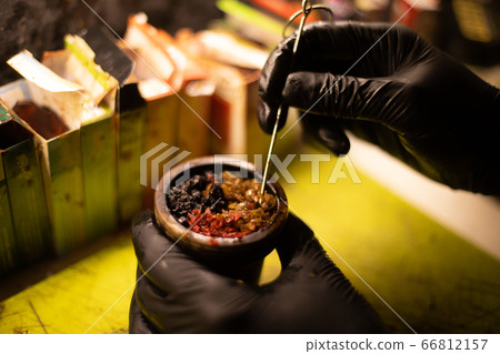 Preparation of Hookah bowl with tabacco leaf hands Preparation of Hookah bowl with tabacco leaf hands 66812157