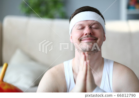 Smiling young man practicing yoga at home 66812790