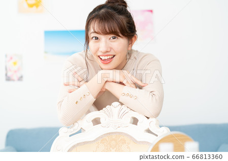 Portrait of smiling young woman looking at camera in living room at home Portrait of smiling young woman looking at camera in living room at home 66813360