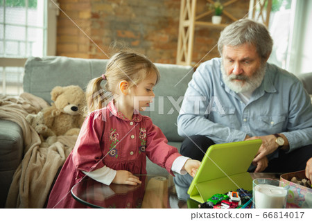 Grandfather and child playing together at home. Happiness, family, relathionship, education concept. Grandfather and child playing together at home. Happiness, family, relathionship, education concept. 66814017