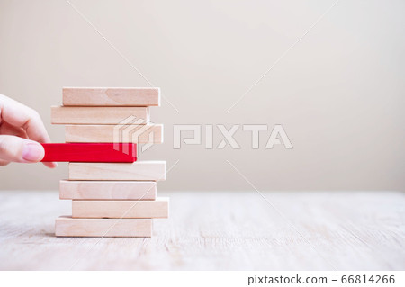 Businessman hand placing or pulling red wooden 66814266