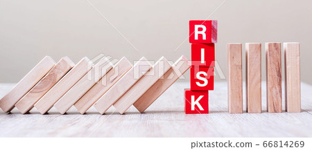 Red RISK cube blocks stop falling blocks on table. Red RISK cube blocks stop falling blocks on table. 66814269