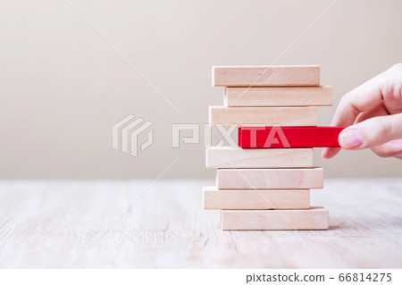 Businessman hand placing or pulling red wooden Businessman hand placing or pulling red wooden 66814275
