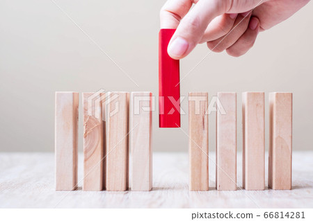 Businessman hand placing or pulling Red wooden 66814281