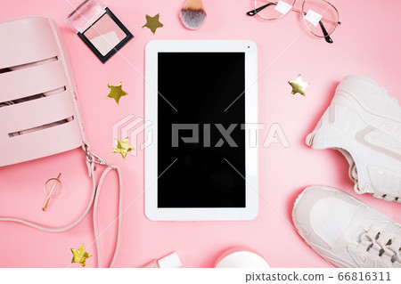 Tablet mock-up on the pink background with feminine outfit and make-up, top view. 66816311