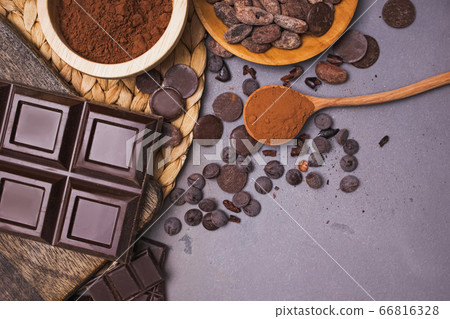 Chocolate pieces and drops, cocoa beans and powder on grey background 66816328