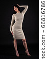 Woman in beige tight dress on black 66816786