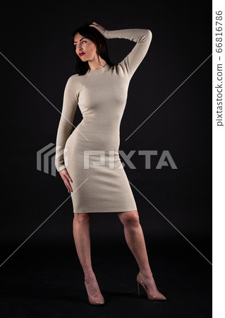 Woman in beige tight dress on black Woman in beige tight dress on black 66816786