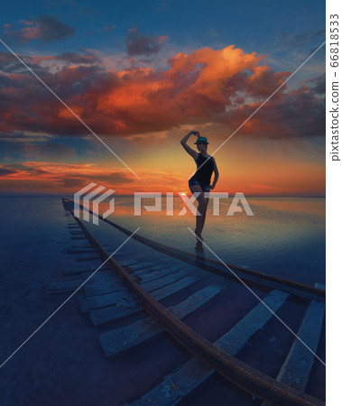 Woman at beauty sunset on salty lake Woman at beauty sunset on salty lake 66818533