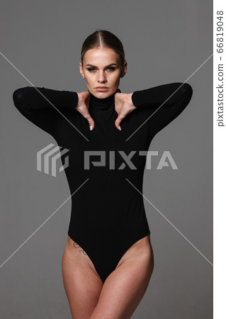 Beautiful Woman In Black Leotard Posing On Grey Background Stock