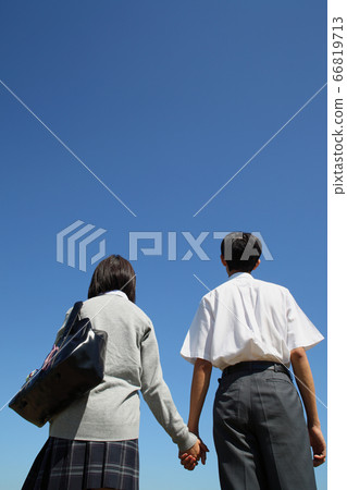 握手的男性和女性高中學生後視圖 握手的男性和女性高中學生後視圖 66819713