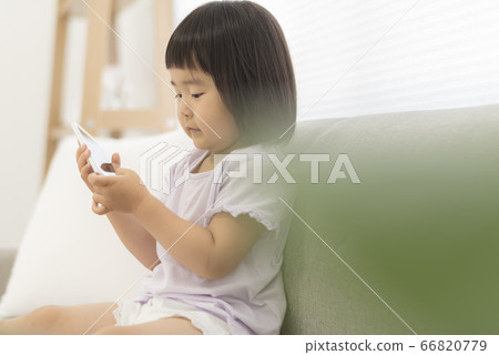 3 year old child making a phone call with a smartphone 66820779