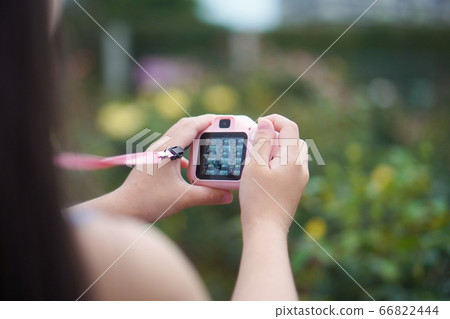 A first grade girl is having fun taking pictures with a kids' camera A first grade girl is having fun taking pictures with a kids' camera 66822444