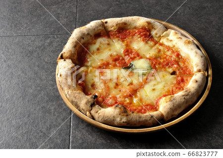 Margherita, one of the Neapolitan pizzas placed on a wooden plate 66823777