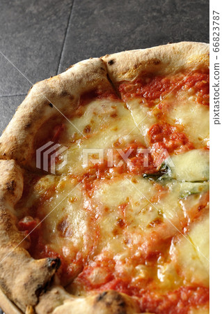 Margherita, one of the Neapolitan pizzas placed on a wooden plate Margherita, one of the Neapolitan pizzas placed on a wooden plate 66823787