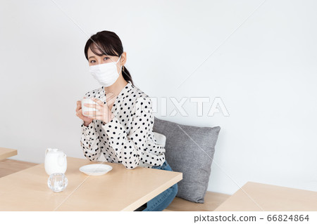 Woman wearing mask wearing tea at cafe Woman wearing mask wearing tea at cafe 66824864