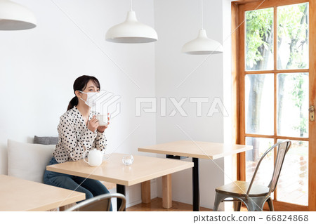 Woman wearing mask wearing tea at cafe Woman wearing mask wearing tea at cafe 66824868