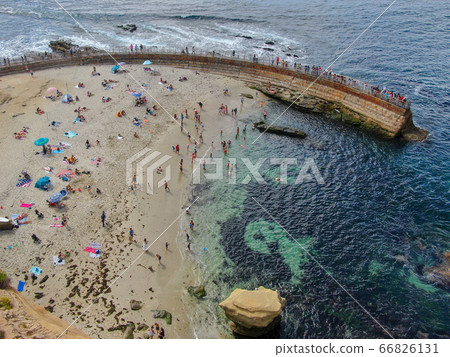 Beachgoers enjoying a beautiful sunny afternoon at La Jolla Cove 66826131