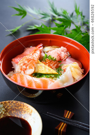 Bowl of rice topped with sashimi  66826592
