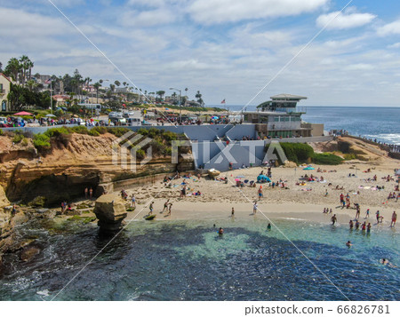 Beachgoers enjoying a beautiful sunny afternoon at La Jolla Cove 66826781