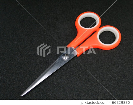 Orange scissors on black background in studio light Orange scissors on black background in studio light 66829880