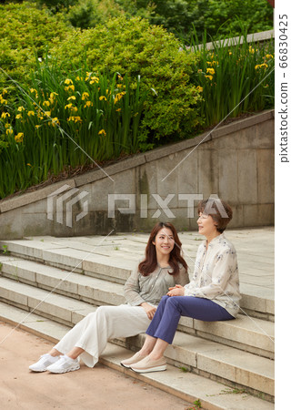 Mother and daughter walking 66830425