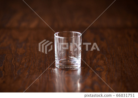 Empty elegant clean glass on the dark wooden table Empty elegant clean glass on the dark wooden table 66831751