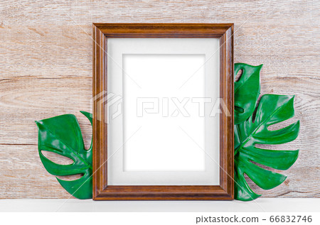 Empty wooden photo frame on green leaves. Empty wooden photo frame on green leaves. 66832746