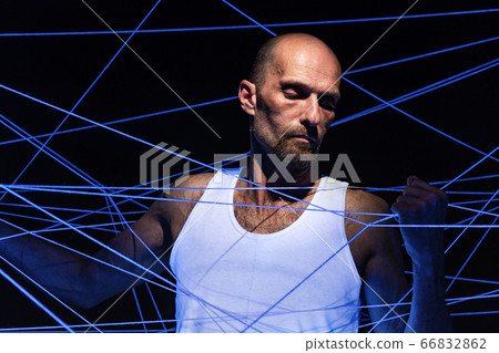 Photo of adult man tangled in white rope in ultraviolet Photo of adult man tangled in white rope in ultraviolet 66832862