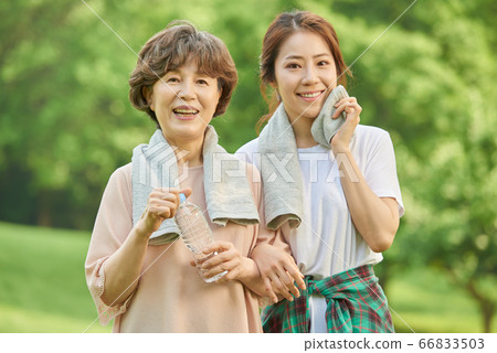 Mother and daughter exercising 66833503