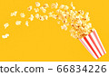popcorn in classic bucket red and white splashing out of the box 66834226