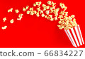 popcorn in classic bucket red and white splashing out of the box 66834227