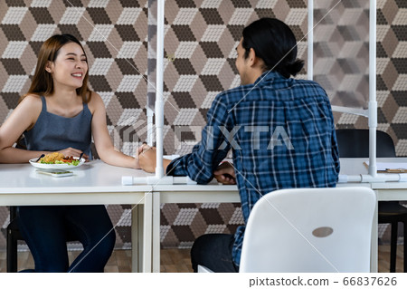 Asian couple eating out at new normal restaurant Asian couple eating out at new normal restaurant 66837626