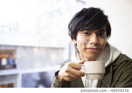A man relaxing at a cafe 66839236