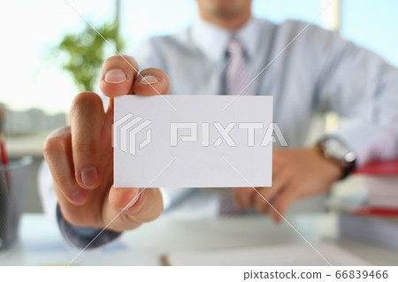Businessman giving calling card to visitor in office Businessman giving calling card to visitor in office 66839466