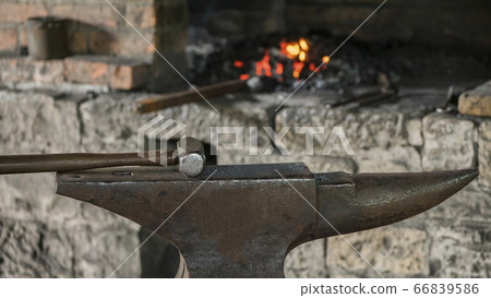 Old smithy - a heavy blacksmiths hammer lies on a huge anvil Old smithy - a heavy blacksmiths hammer lies on a huge anvil 66839586