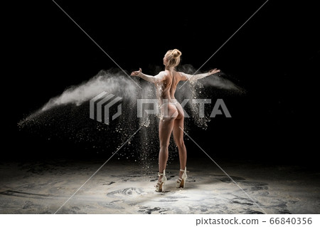 Anonymous topless woman throwing sand in air Anonymous topless woman throwing sand in air 66840356